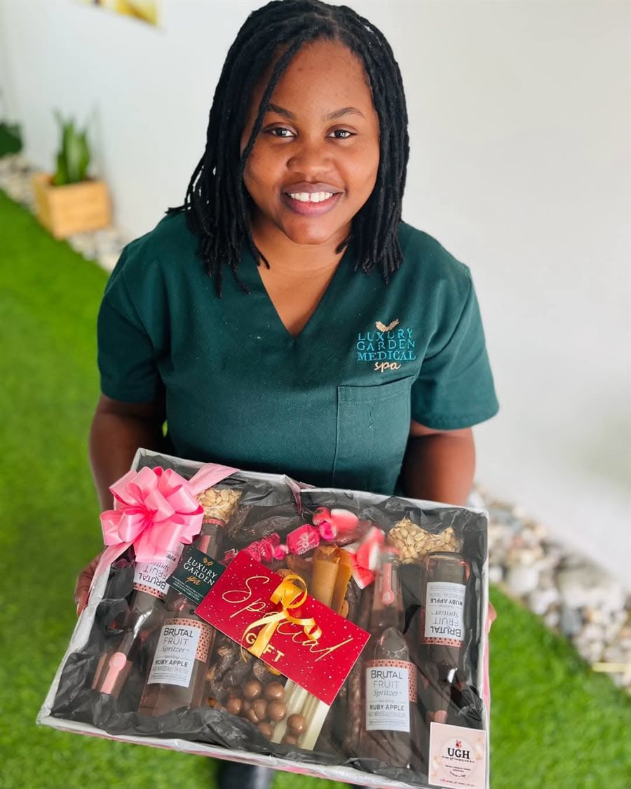 Luxury Garden Medical Spa team member presenting a gift hamper